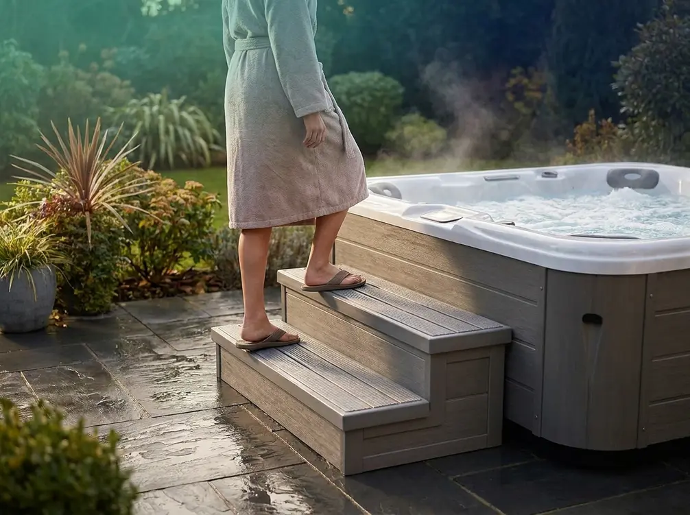 Person safely entering a hot tub using wide non-slip polymer spa steps outdoors